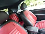 Tilted angle of red and white leather seats in fancy automobile during the daytime