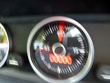 Close up on blurry speedometer or readout inside automobile or other vehicle in motion