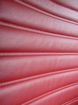 Crop close texture of leather red seat in car.