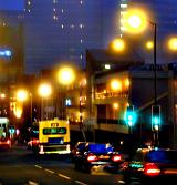 Colorful night scene with town traffic in a busy urban street illuminated by street lamps