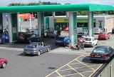 Motorists waiting for petrol or gas in a forecourt of a modern service station with people filling their cars at the pumps