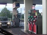 Car refuelling at a service station or garage parked on the forecourt with headlights on in front of the fuel pumps