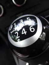 Close up detail of the gear shift knob on a manual car showing six gear selections