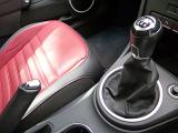 Manual gear lever and hand brake on the console in a modern car with red leather upholstery and black trim