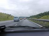 Car driving on a rural motorway in traffic on a rainy cloudy day travelling behind a minibus and cars