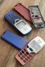 Assorted old mobile phone covers or cases in red blue and black for push button phones, some broken and damaged