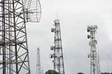 Series of communications towers with antennae for mobile phones on a grey cloudy today
