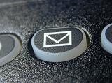 Envelope mail or message icon on a black keypad with buttons on a retro telephone or cellphone in a communication concept