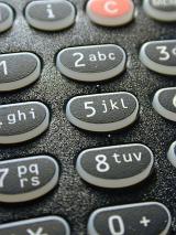 Alphanumeric keypad on a telephone with black keys showing numbers and letters in a communications concept