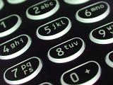 Alphanumeric button keypad with numerals and letters on an old black mobile phone in a close up view