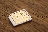 Micro-sim card for a mobile phone on a wooden background with shallow dof and partial focus in a communication concept