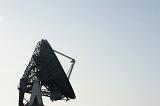 Silhouette of a parabolic ground satellite dish antenna against a clear blue sky with copy space in a concept of telecommunication