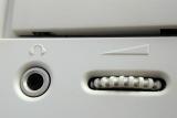 Close up detail of a ridged CD ROM volume control knob on a white machine in a technology, data storage and entertainment concept