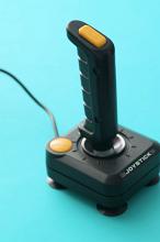 Retro joy stick for video gaming with handle and buttons on a blue background in a personal entertainment concept
