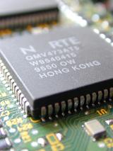 Close-up microchip installed on printed circuit board with Hong Kong label, selective focus detail view