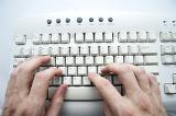 a pair of hands typing at a computer keyboard