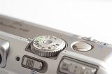 Close up view of the controls on a compact camera with the function and program dial and shutter button isolated on white with copy space