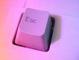 an excape button an a computer keyboard illuminated in pink light