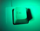 Close up view of a white computer Escape key in green light in a computing and communications concept