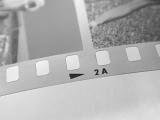Close up detail of the sprockets on a developed 35mm film strip in a retro photography concept