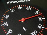 Circular hygrometer gauge measuring humidity or water vapor in the atmosphere with the needle pointing to 75 percent
