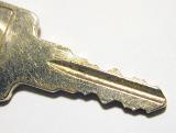 Macro view of the shaft of a scratched used steel key in a safety and security concept over a white background with copy space