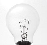 Close up on a glass incandescent light bulb showing the filament and wiring in an energy and power concept