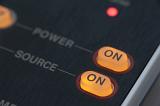 Illuminated orange on-off power buttons on an electronic device or panel in a close up view