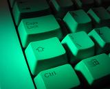 Shift and control keys on a white computer keyboard illuminated by a green light in a close up background view
