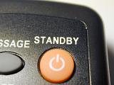 Orange standby button on a keypad on a remote control or electronic device with a power icon and text above