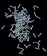 Pile of small screws with spread over black background