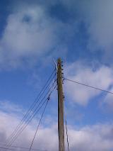 Low angle view looking up at a wooden telephone pole