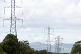Electricity pylons with high voltage cables crossing mountainous terrain in a concept of power and energy distribution