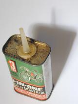 Vintage oiler canister with oil for bicycles, viewed from high angle on white table