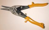 Pair of tin snips with yellow handles on a white studio background with copy space conceptual of DIY, maintenance, and workshop repair