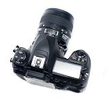 Overhead view of a black DSLR digital camera and lens with blank led displays isolated on white