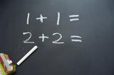 Two addition sums on blackboard explained by Math teacher.