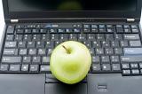 Education comcept: Green apple above black keyboard laptop personal computer.