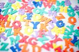Close up shot of random colorful letters on white background