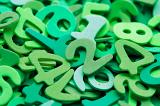 Random pile of green plastic numbers for use in a kindergarten or preschool to teach young children to count and do basic maths