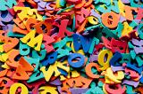 Random pile of mulitcoloured plastic alphabet letters for use in a kindergarten or preschool to teach young children basic language skills and to read, spell and write