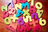 Collection of random colourful plastic numbers and mathematical symbols for teaching young children in school