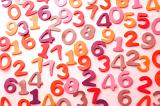 Colourful array of numbers scattered randomly on a white surface in an education and learning concept for teaching young children mathematics