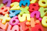 Closeup of colourful plastic toy numbers and symbols for teaching kindergarten children basic mathematics