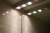 a row of halogen lights over a bathroom mirror