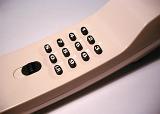 Landline telephone handset and keypad in a close up view of the black keys in a telecommunication concept
