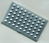 Close up overhead view of a metal business cardholder with raised bumps in rows of six