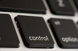 Black computer control button or key on a keyboard viewed obliquely close up