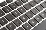 Qwerty computer keyboard with black keys in a close up view of the letters, numbers and functions