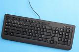 Single black keyboard with extended numeric keypad from top down view over blue background